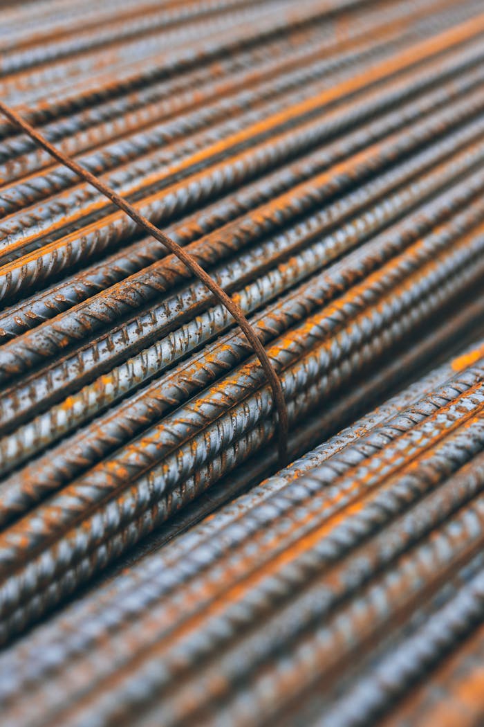 Detailed view of rusty steel rebars stacked in parallel pattern highlighting construction materials' texture.